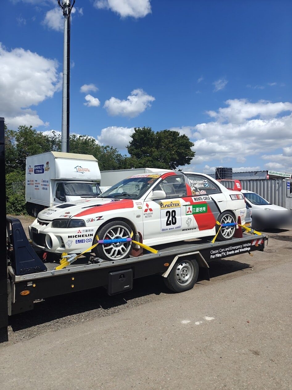Evo IV rally car strapped to a transporter trailer heading to a hire location